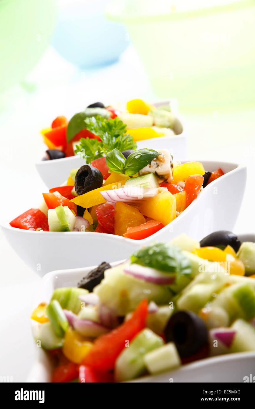 Greek salad with onions, tomatoes, capsicum, feta and olives in small bowls Stock Photo