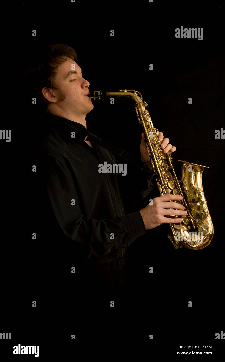 Young musician playing an alto saxophone Stock Photo Alamy