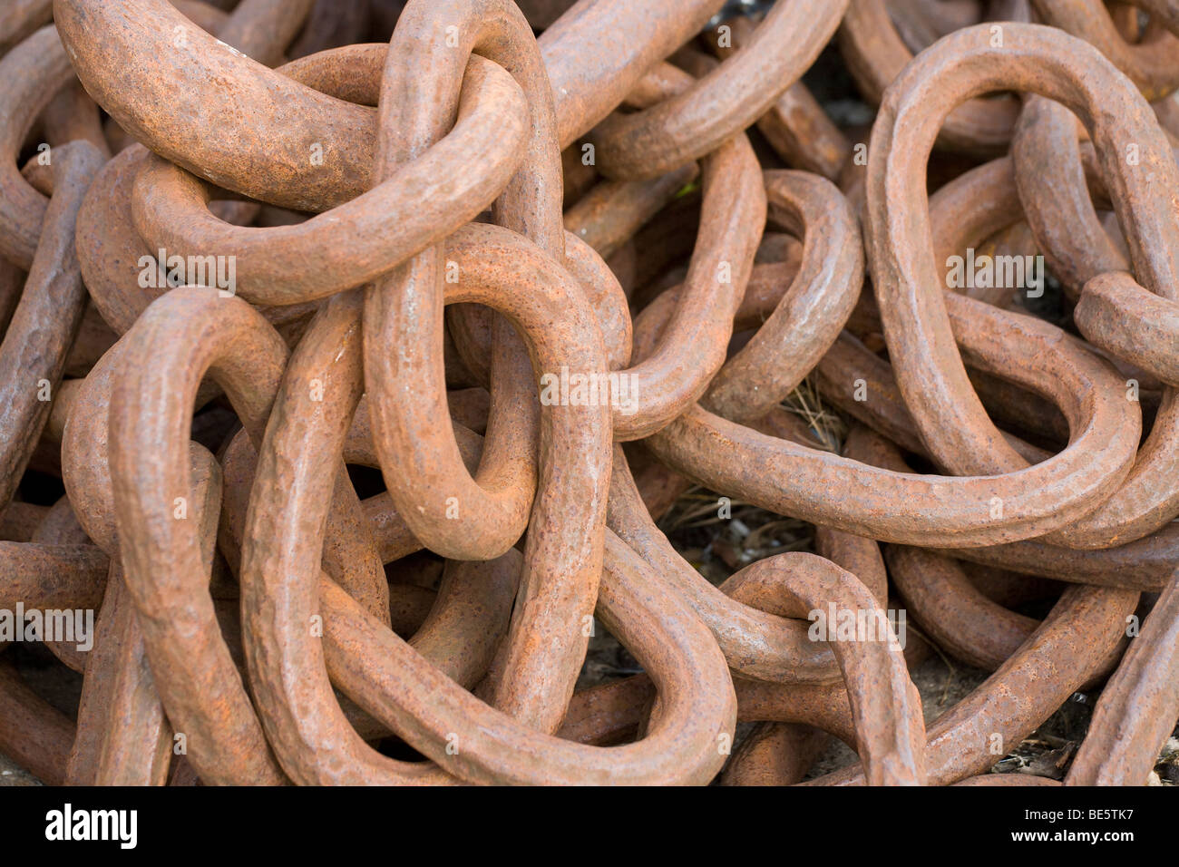 Rusty Chain Links. A pile of large rusting chain links that once formed