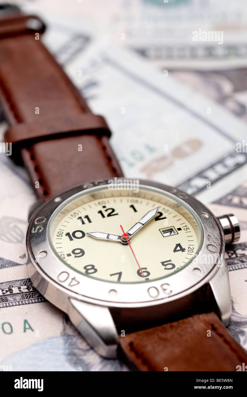 Vertical image of a wristwatch on American currency Stock Photo