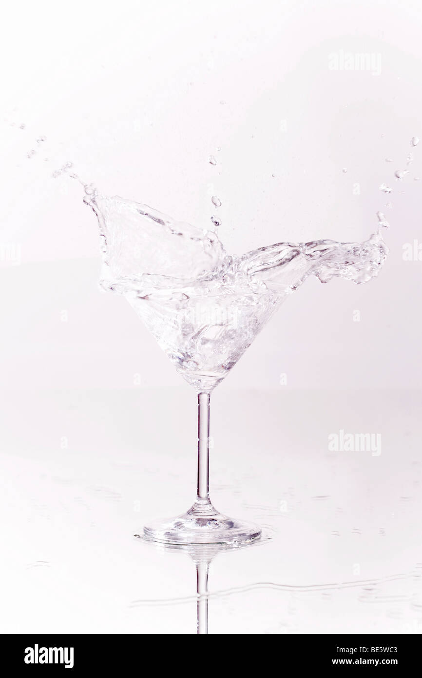 Ice cube falling into a Martini glass Stock Photo