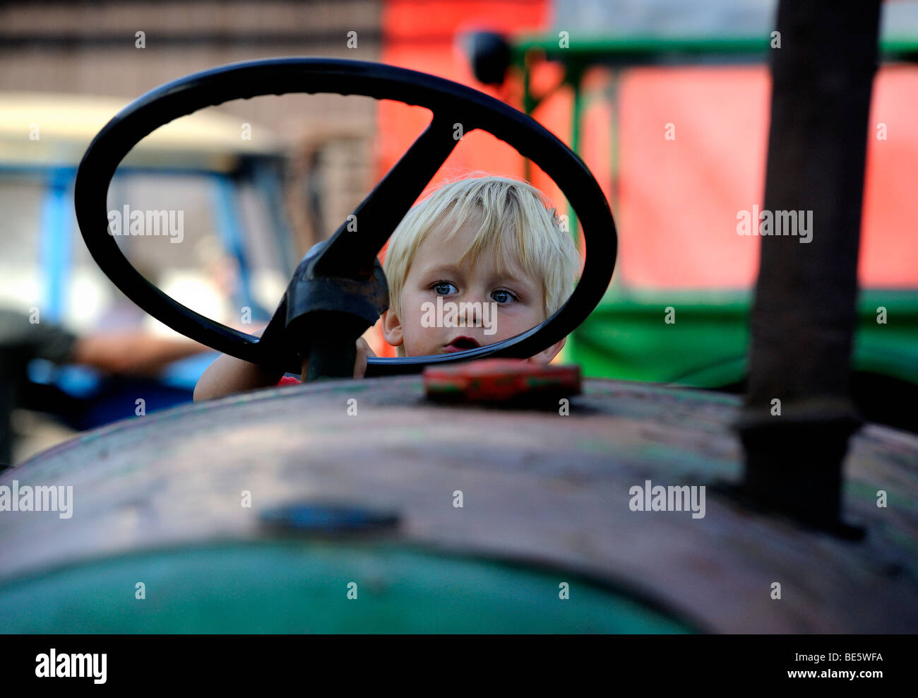 Child blond Boy driving a vintage tractor engine Stock Photo - Alamy