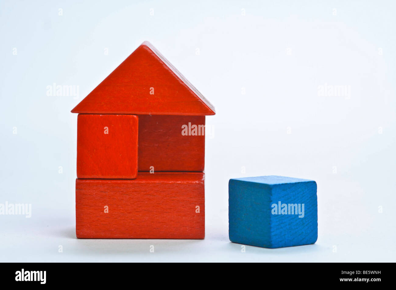 Red house made of building blocks, with a missing blue element Stock Photo