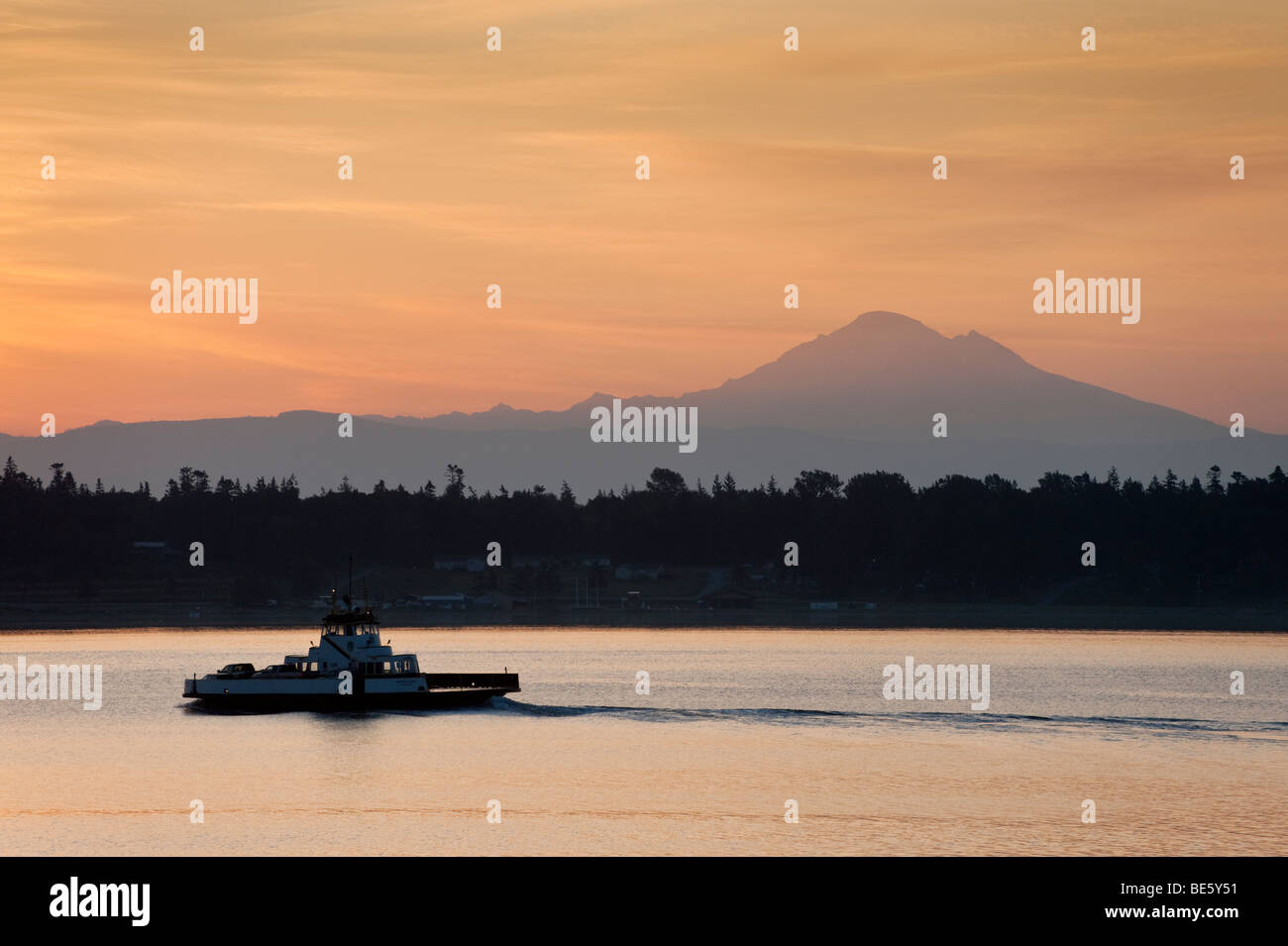 Sunrise over Mt. Baker, Washington and the Lummi Island Ferry. The ferry travels between Lummi Island and the Gooseberry Point. Stock Photo