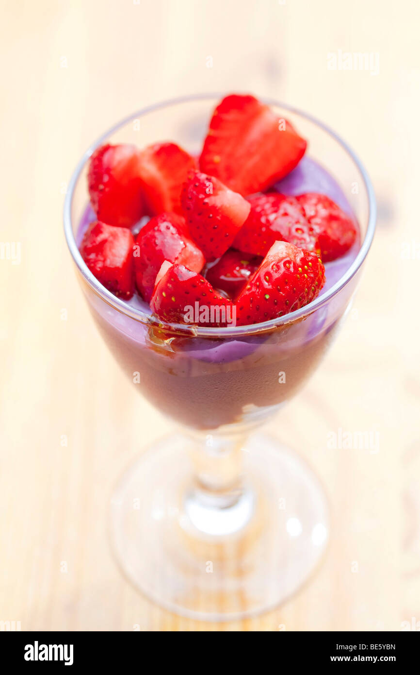 Blueberry yoghurt on cornflakes, topped with honey-covered strawberries Stock Photo