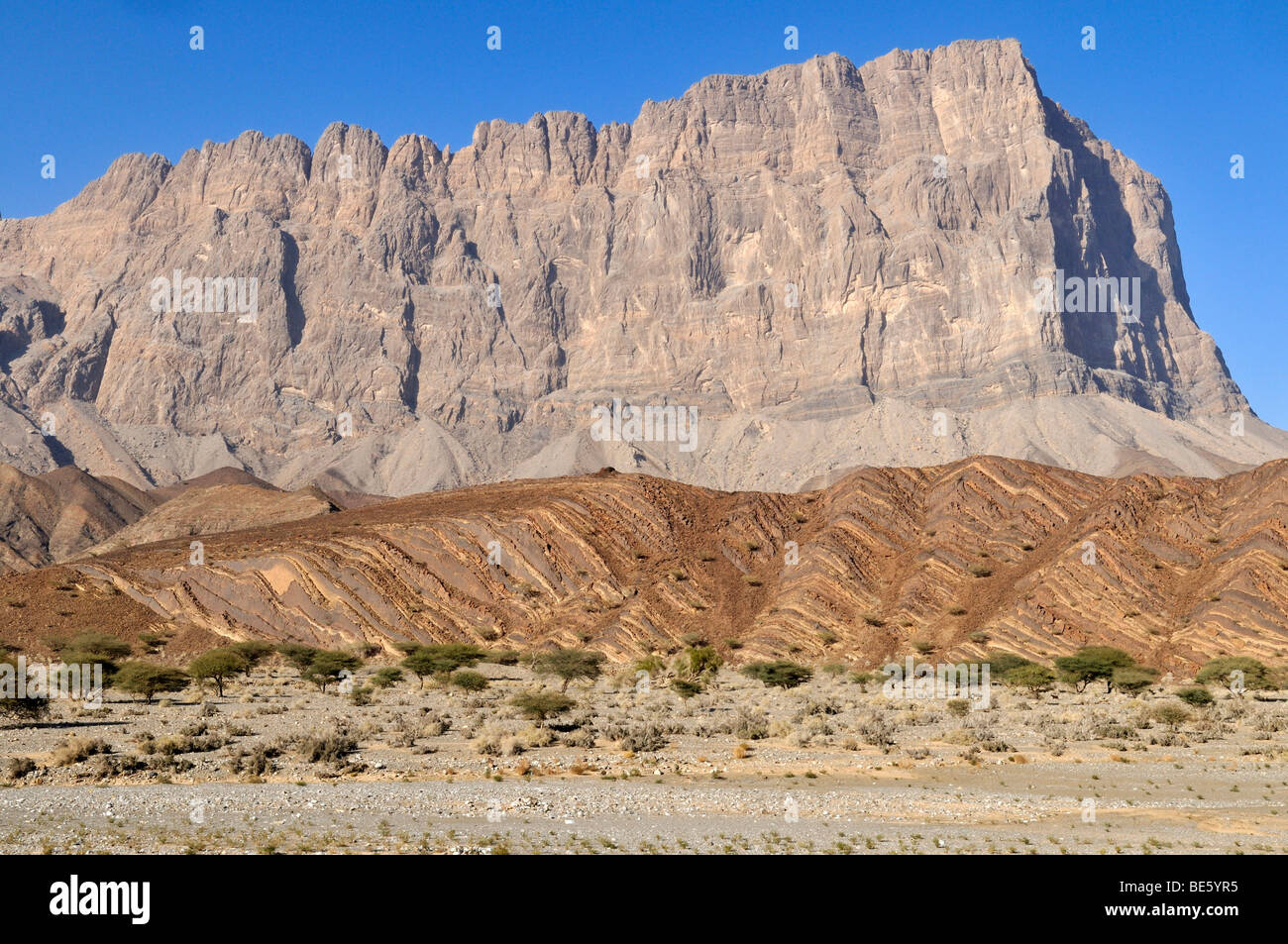 Dry wadi bed in front of Jebel, Jabal Misht, Hajar al Gharbi Mountains, Al Dhahirah region, Sultanate of Oman, Arabia, Middle E Stock Photo