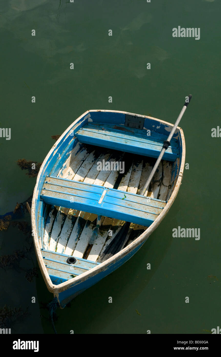 A worn little rowboat floating in a green sea Stock Photo
