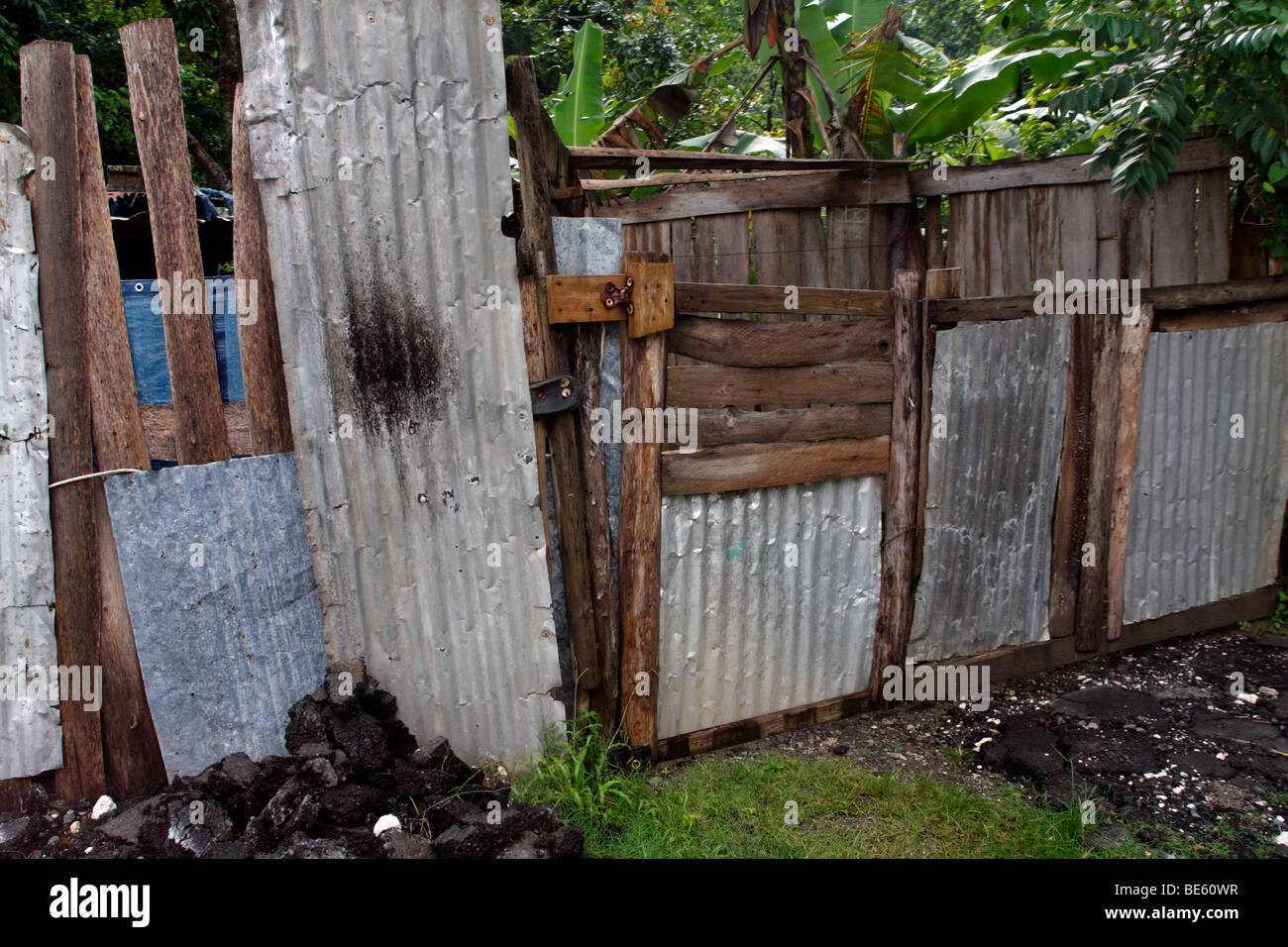 Makeshift fence of corrugated sheet metal and scavenged scraps of lumber. Stock Photo