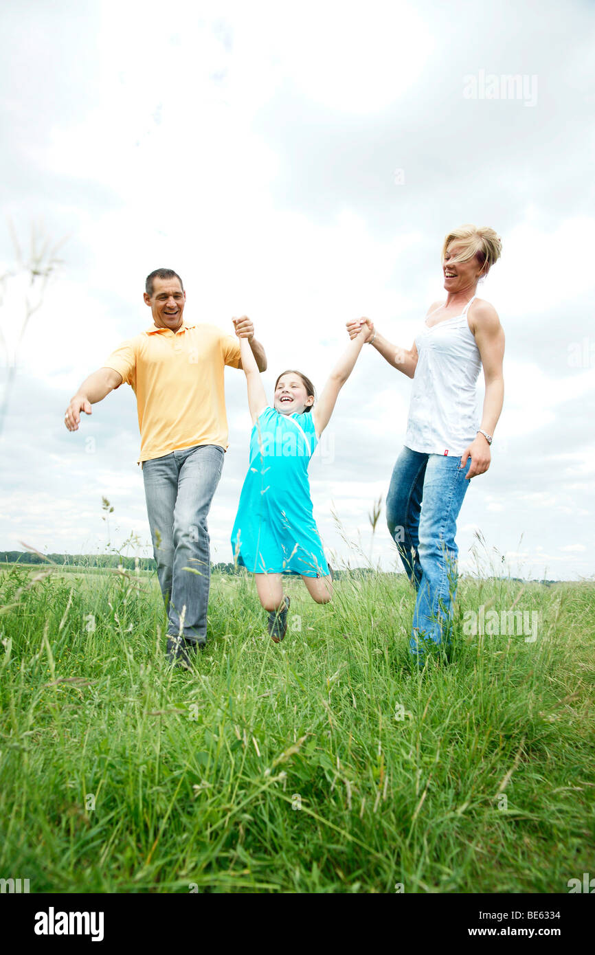Happy family walking across a meadow Stock Photo