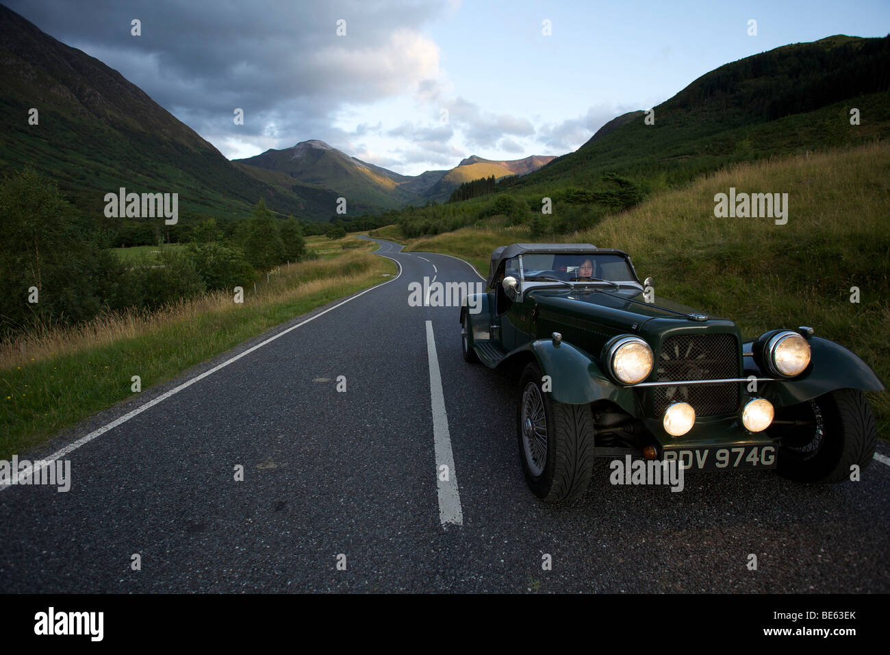 Winding mountain road with classic car, Glen Nevis, Scotland Stock Photo