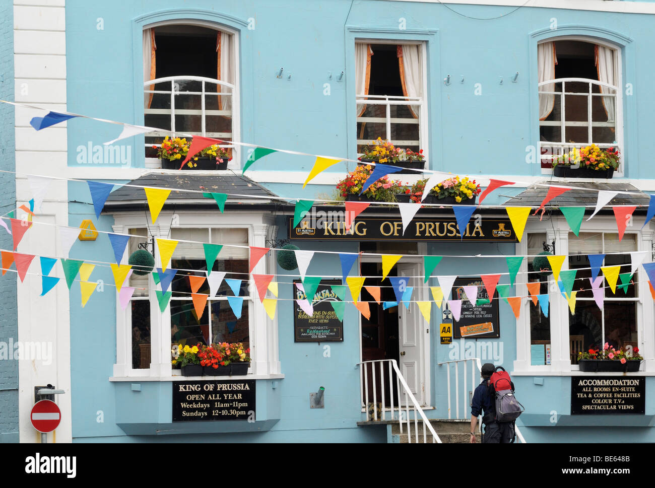Colourful bunting hanging outside King of Prussia public house, Fowey, Cornwall, UK Stock Photo