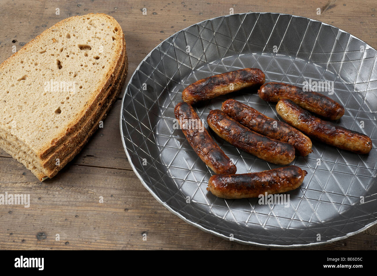Nuernberger bratwurst in an iron pan with bread Stock Photo