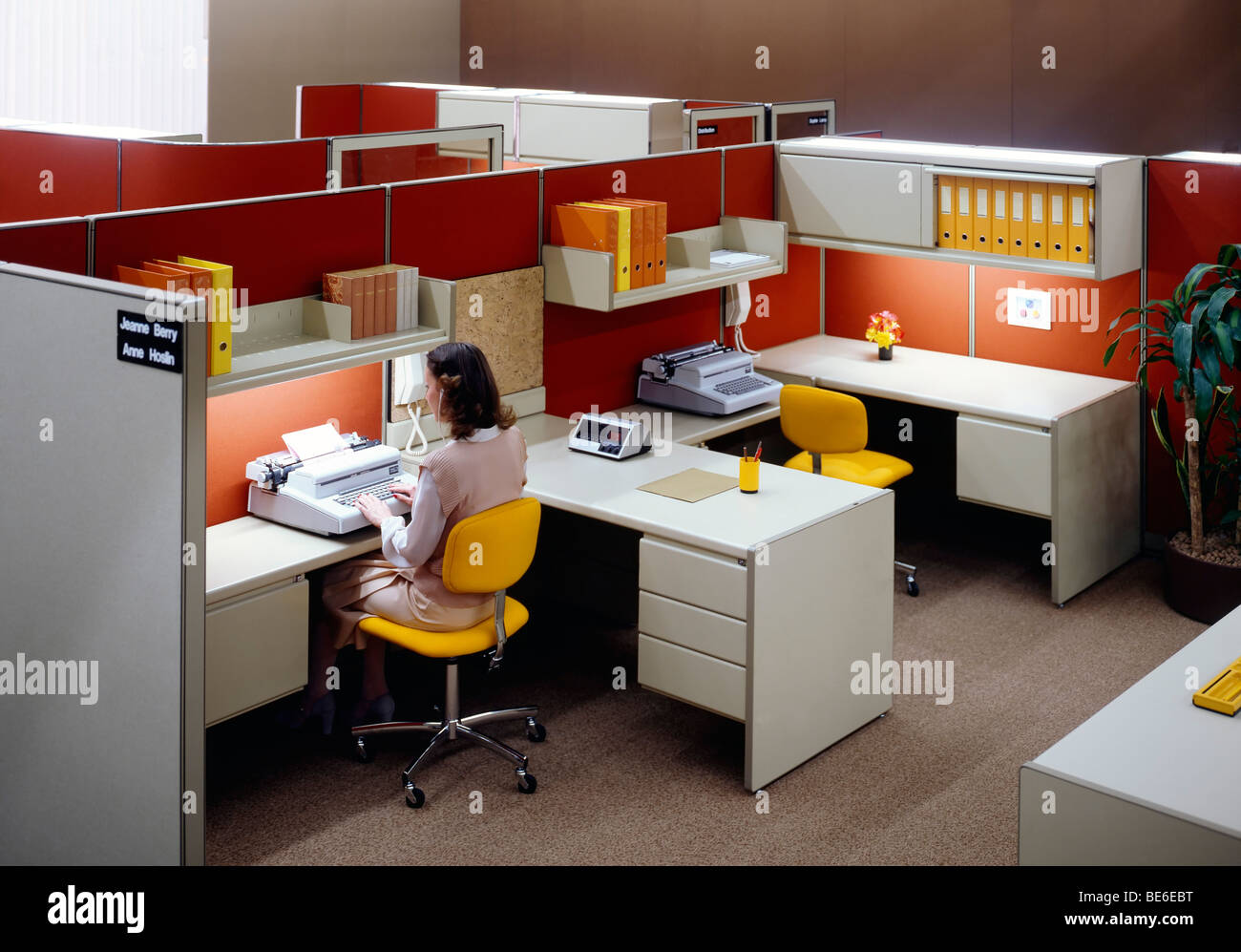 1980s open space office with woman typing Stock Photo