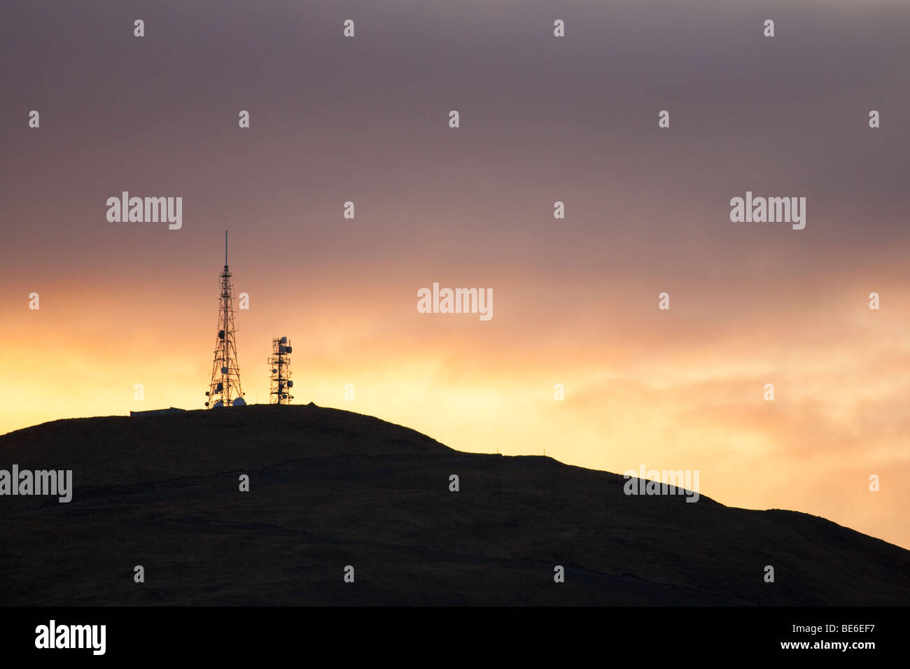 Communication mast silhouetted against dramatic sunset sky Stock Photo ...