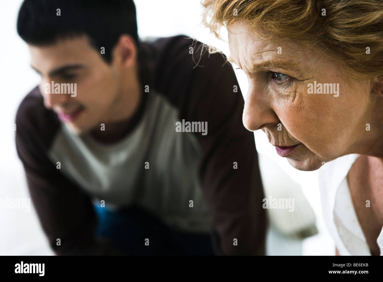 Senior woman looking intently, man in background Stock Photo