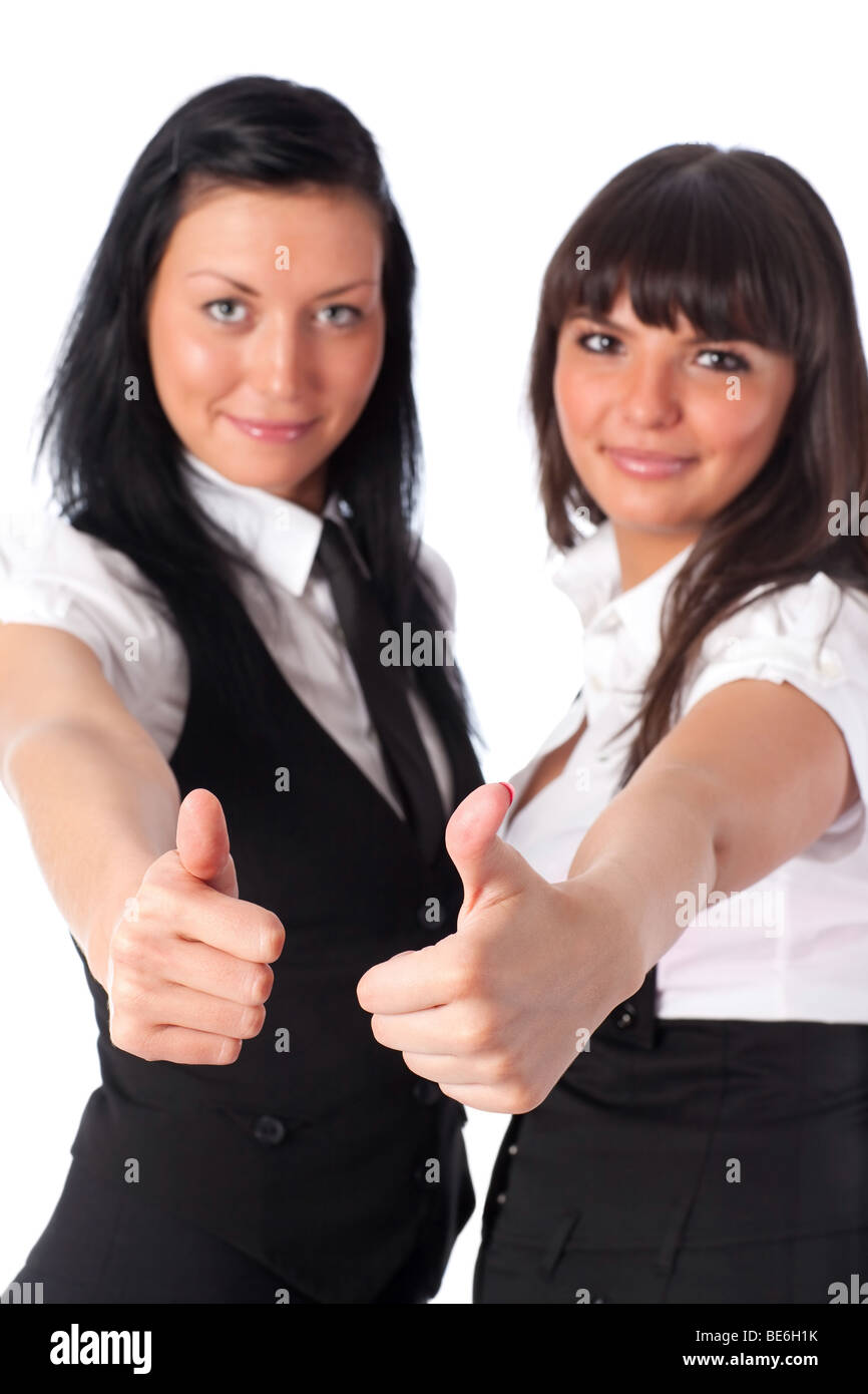 Two young women showing success handsign. Isolated on white. Stock Photo