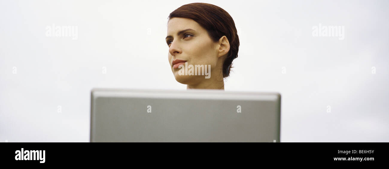 Woman with laptop, looking away Stock Photo