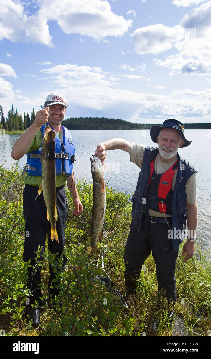 Two fishermen presenting their catch, Northern Pike, Jack, Jackfish (Esox lucius), Caribou Lakes, upper Liard River, Yukon Terr Stock Photo