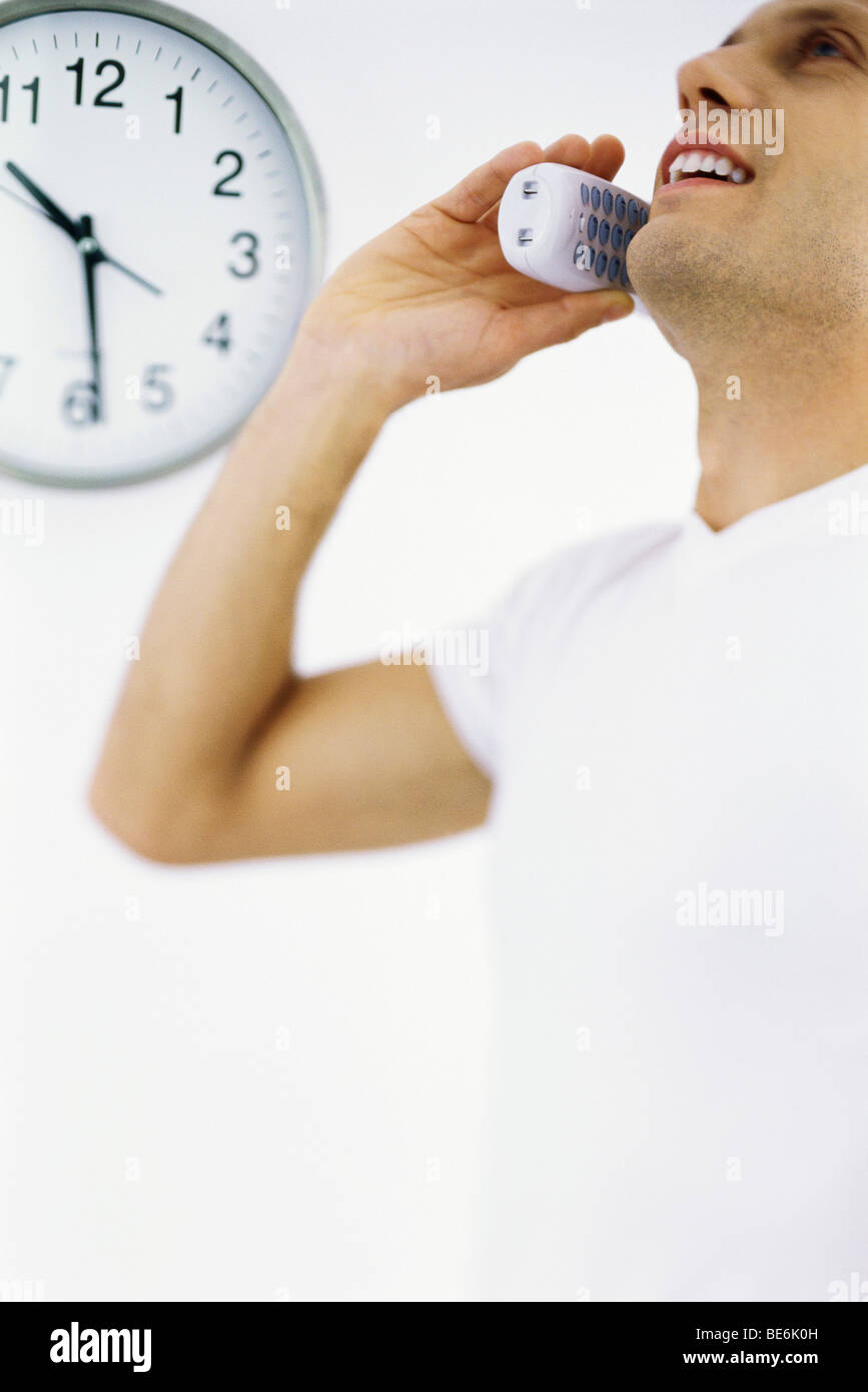 Man on phone call, clock in background Stock Photo Alamy