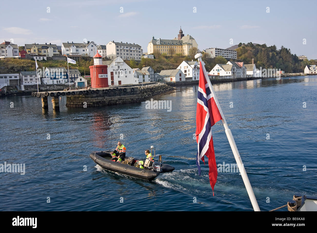 Small rubber boat with crew members travels between cruise ship and
