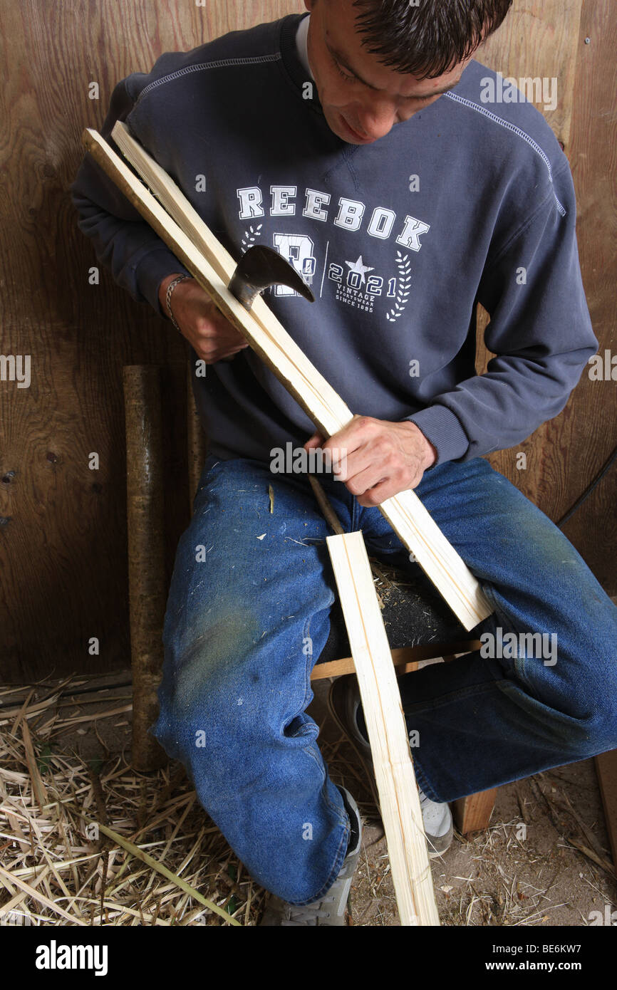 Tony Perkins cutting thatching spars to be used by thatcher Stock Photo