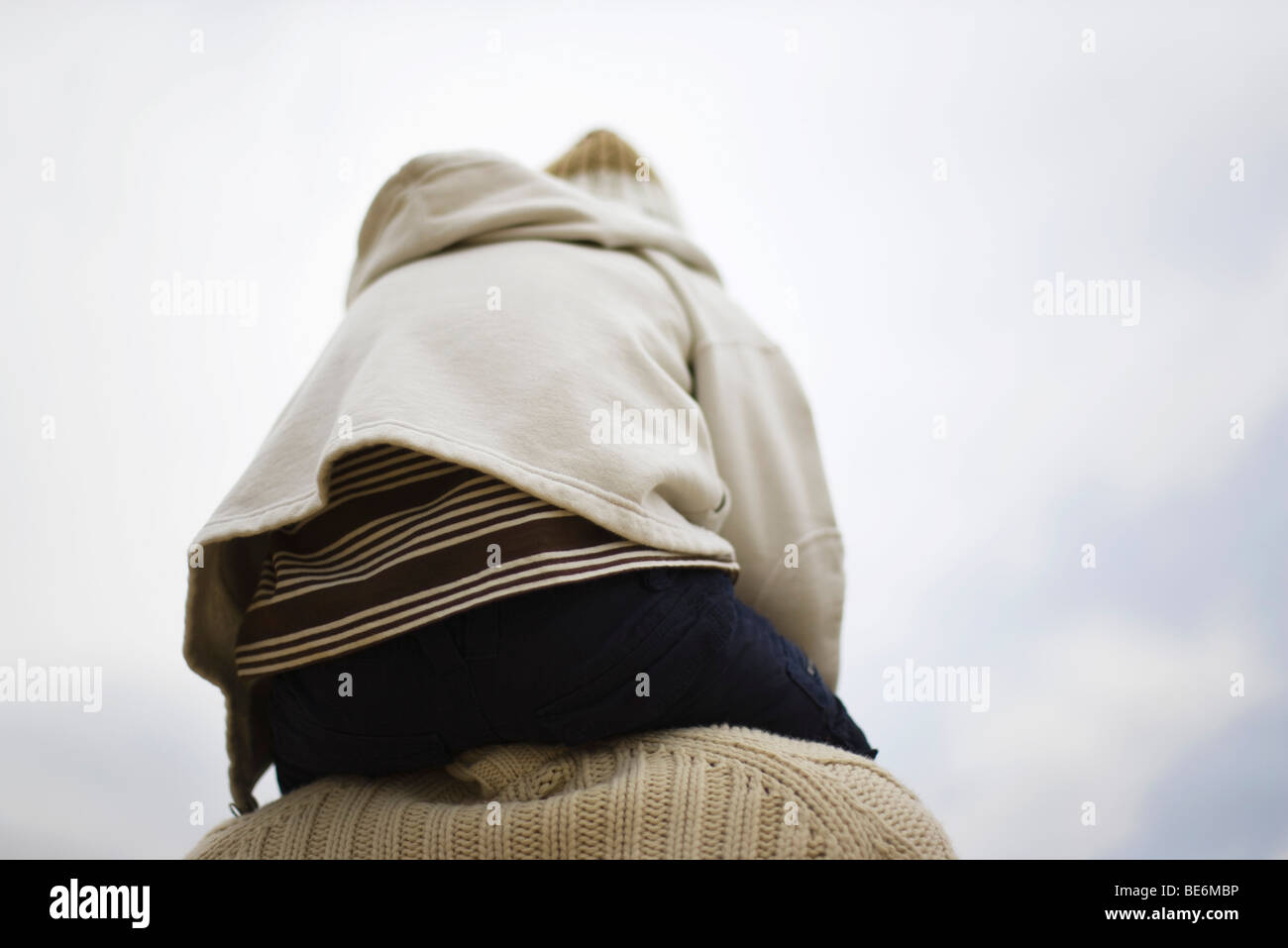 Child sitting on parent's shoulders, rear view Stock Photo - Alamy