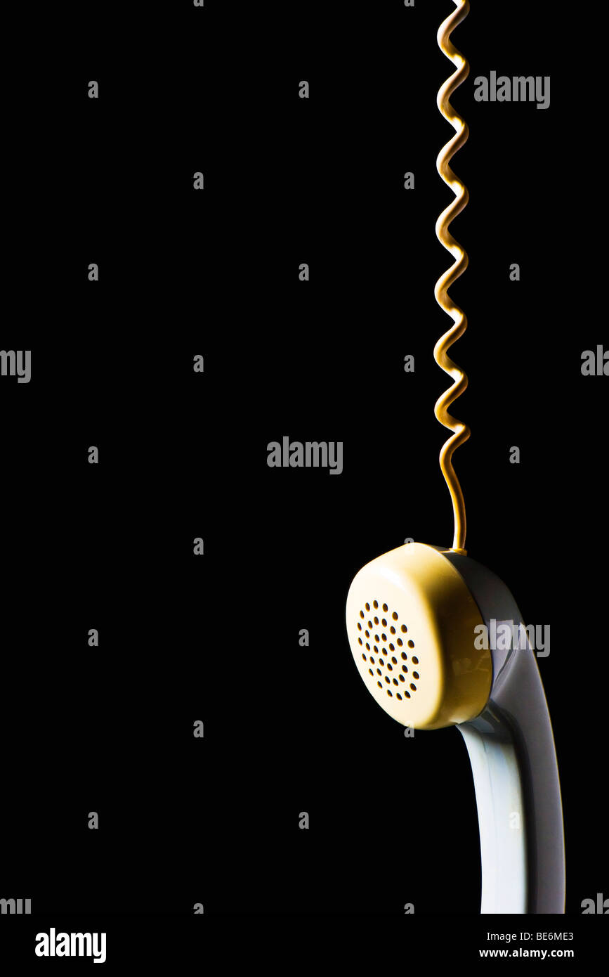 Telephone receiver hanging by cord Stock Photo
