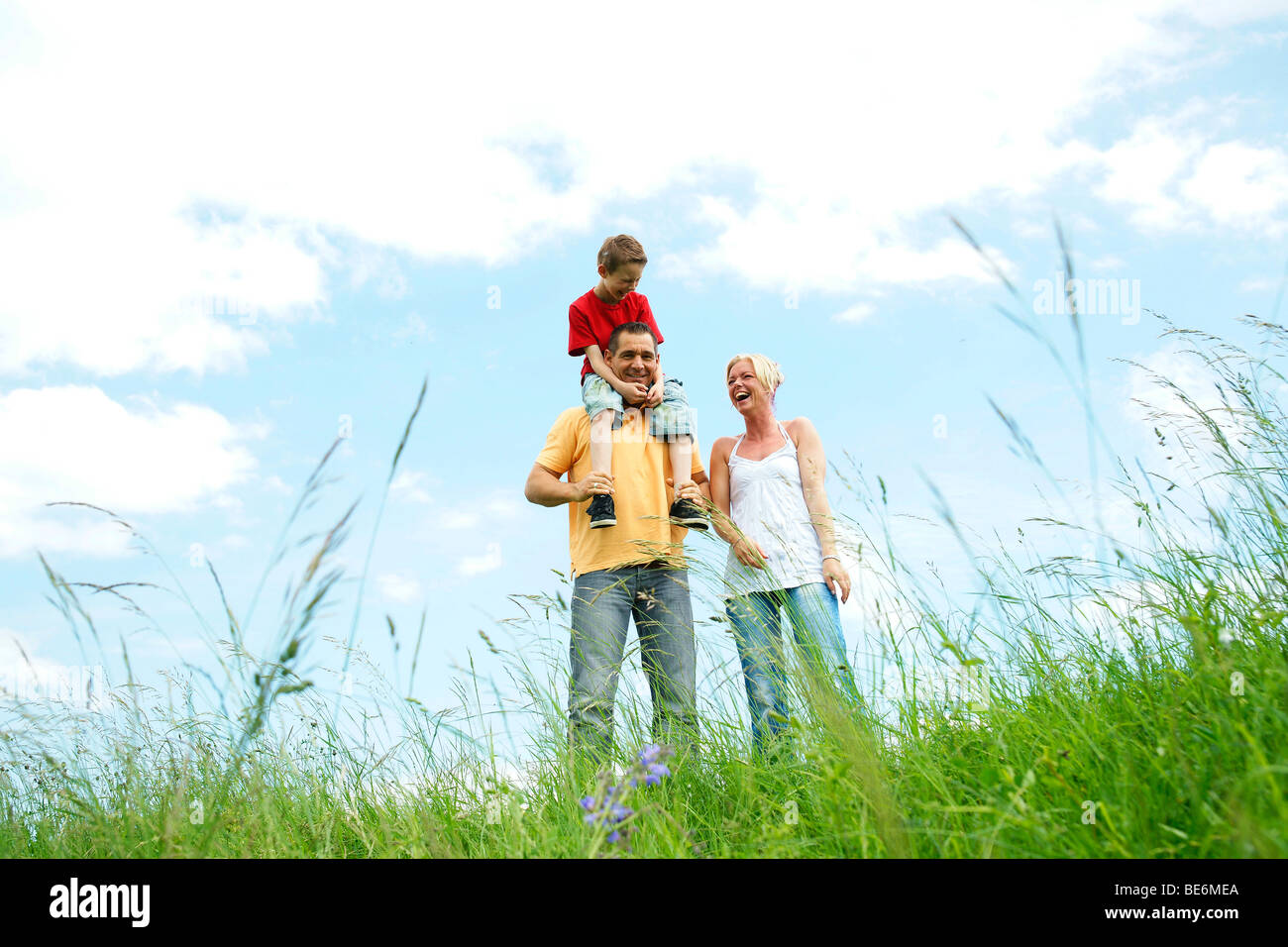 Happy family sitting on a meadow Stock Photo