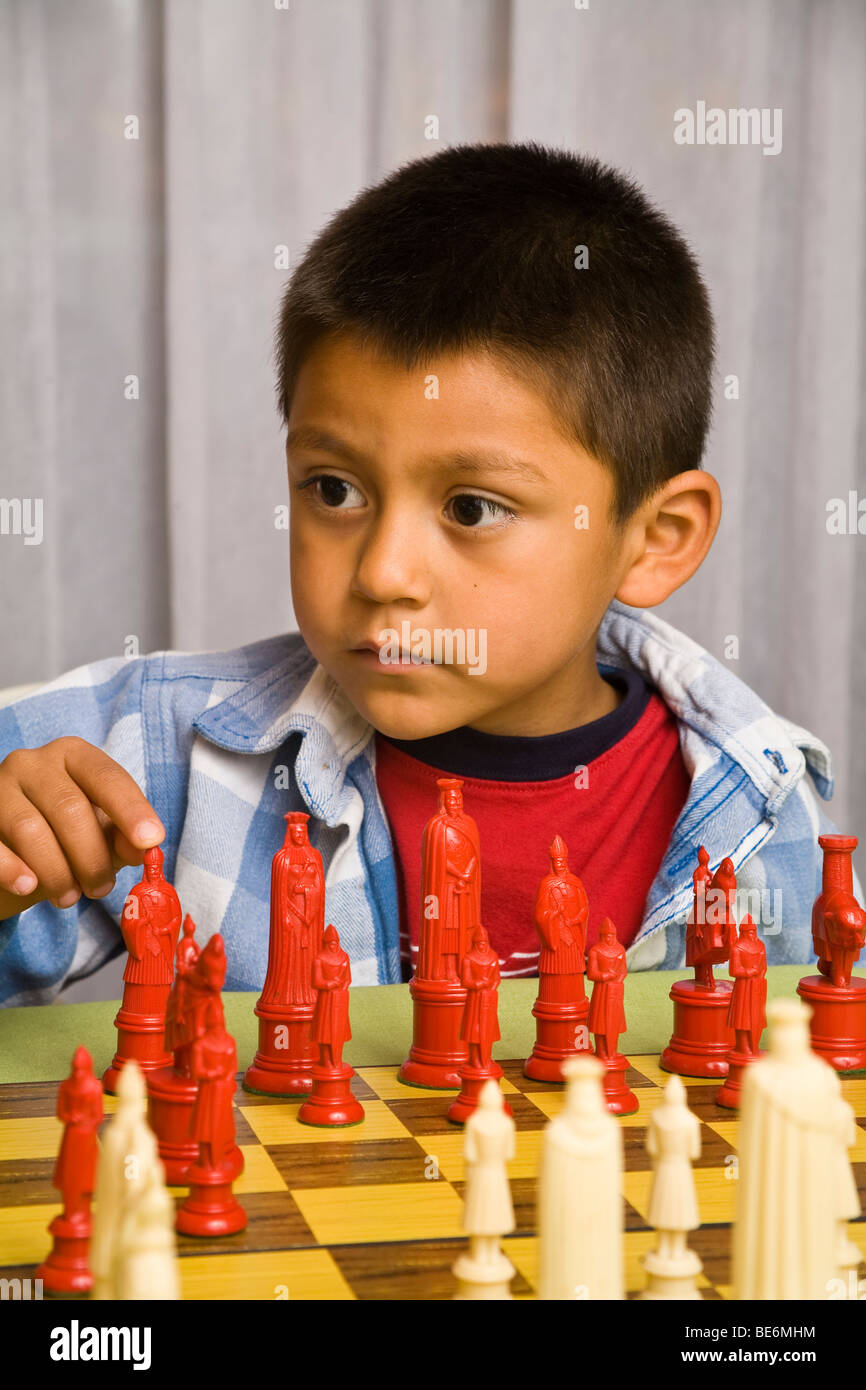 7-8 year old Hispanic boy learning to play chess. MR  © Myrleen Pearson Stock Photo