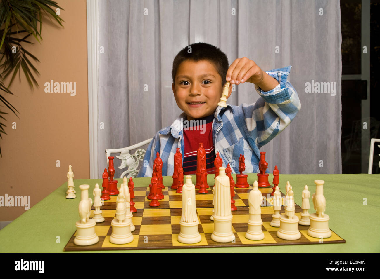 7-8 year old Hispanic boy learning to play chess. MR  © Myrleen Pearson Stock Photo