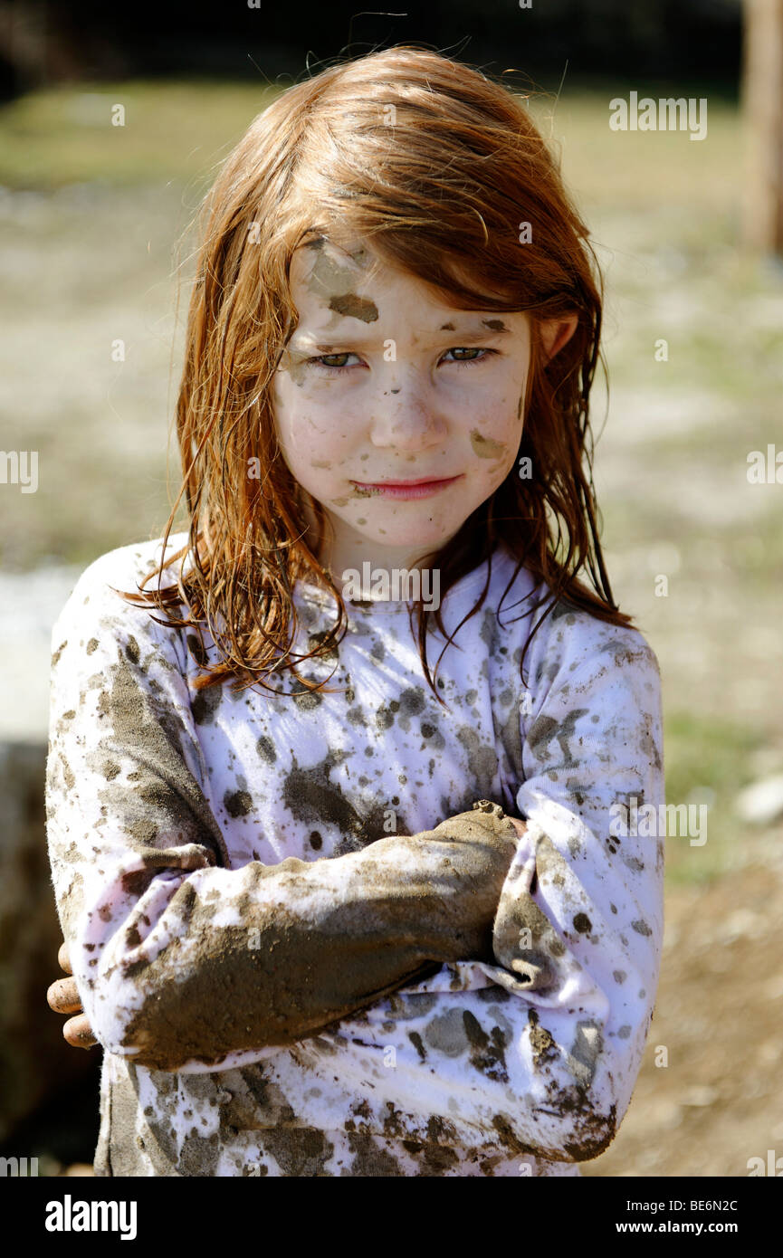 Child totally covered in mud, dirty, wild, untypical girl Stock Photo
