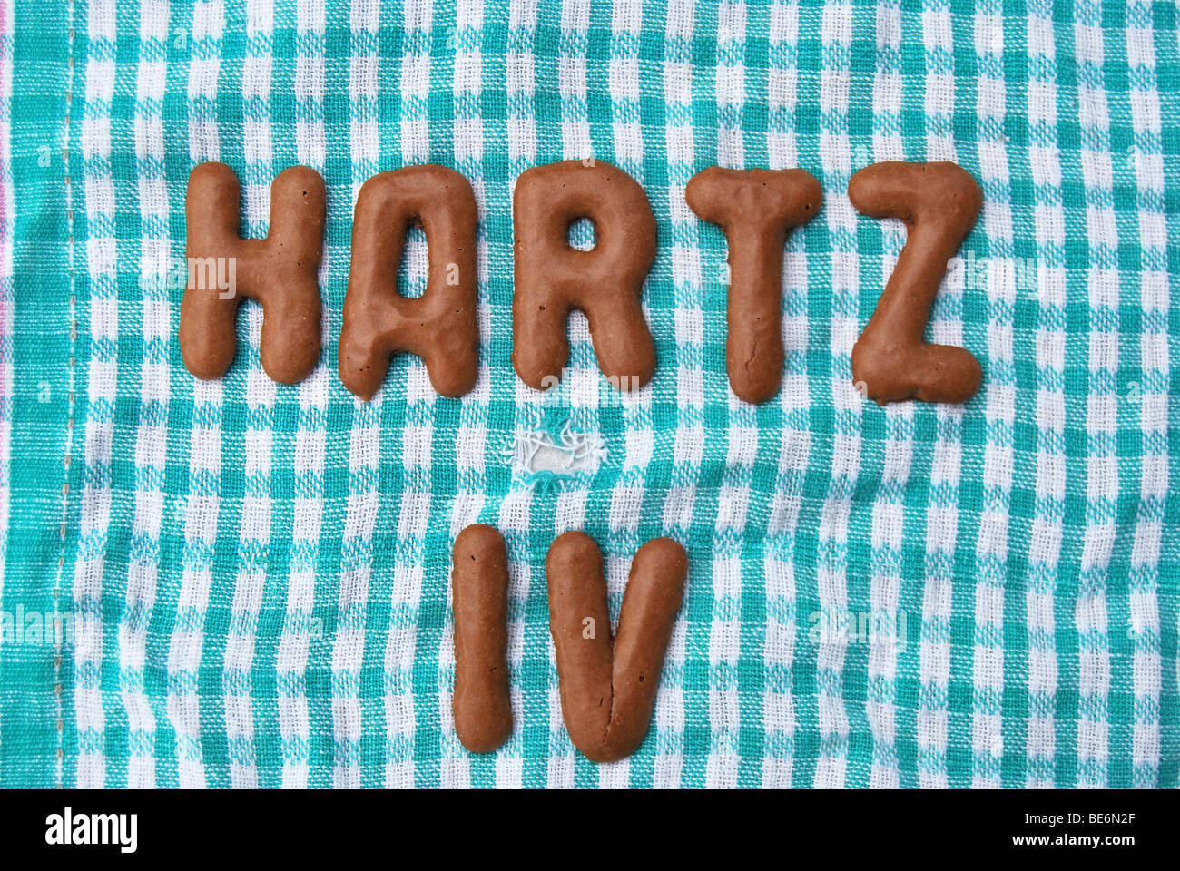 Hartz IV, written with Russian bread letter biscuits on an old teatowel Stock Photo