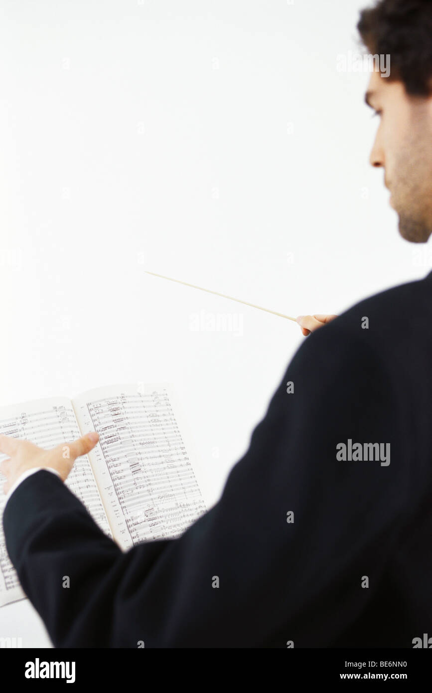 Conductor with musical score and conductor's baton Stock Photo Alamy