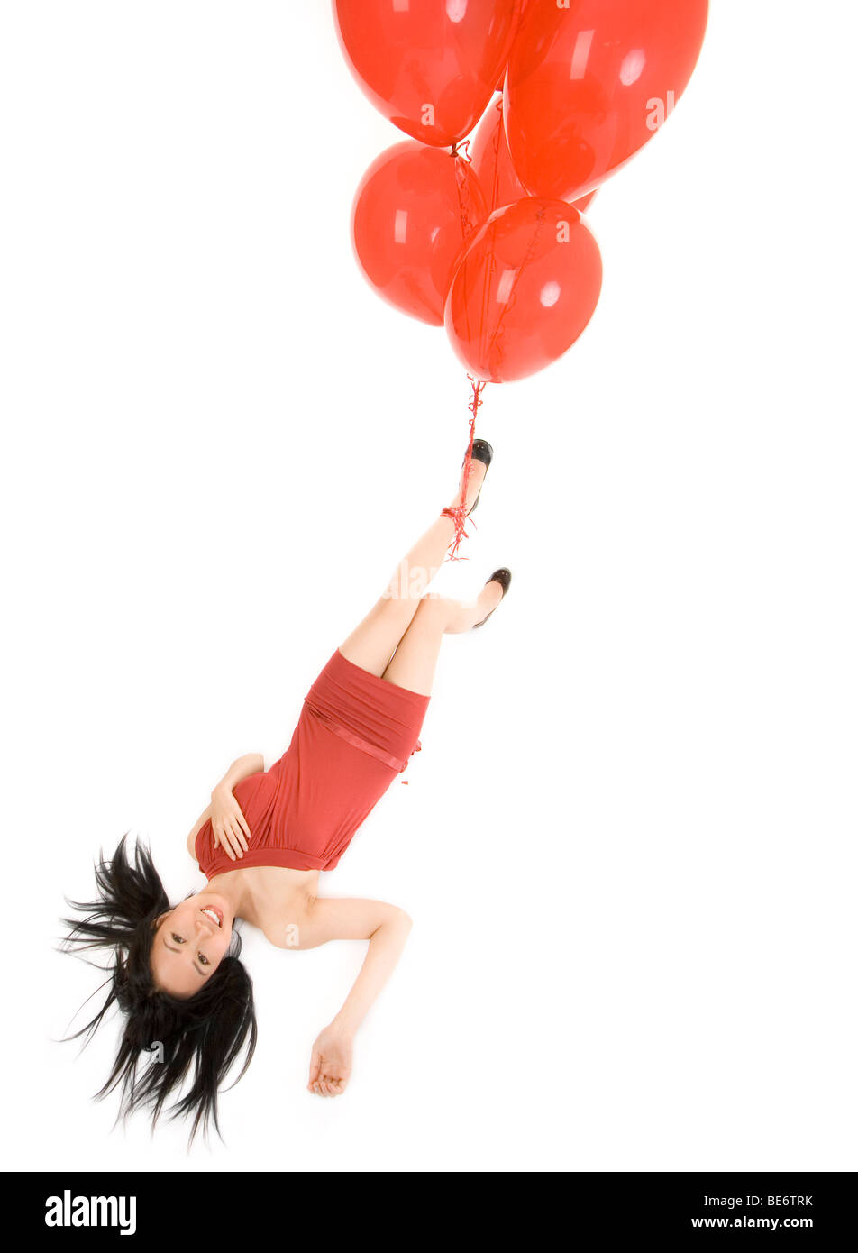 girl with red balloons flingy head over heels Stock Photo