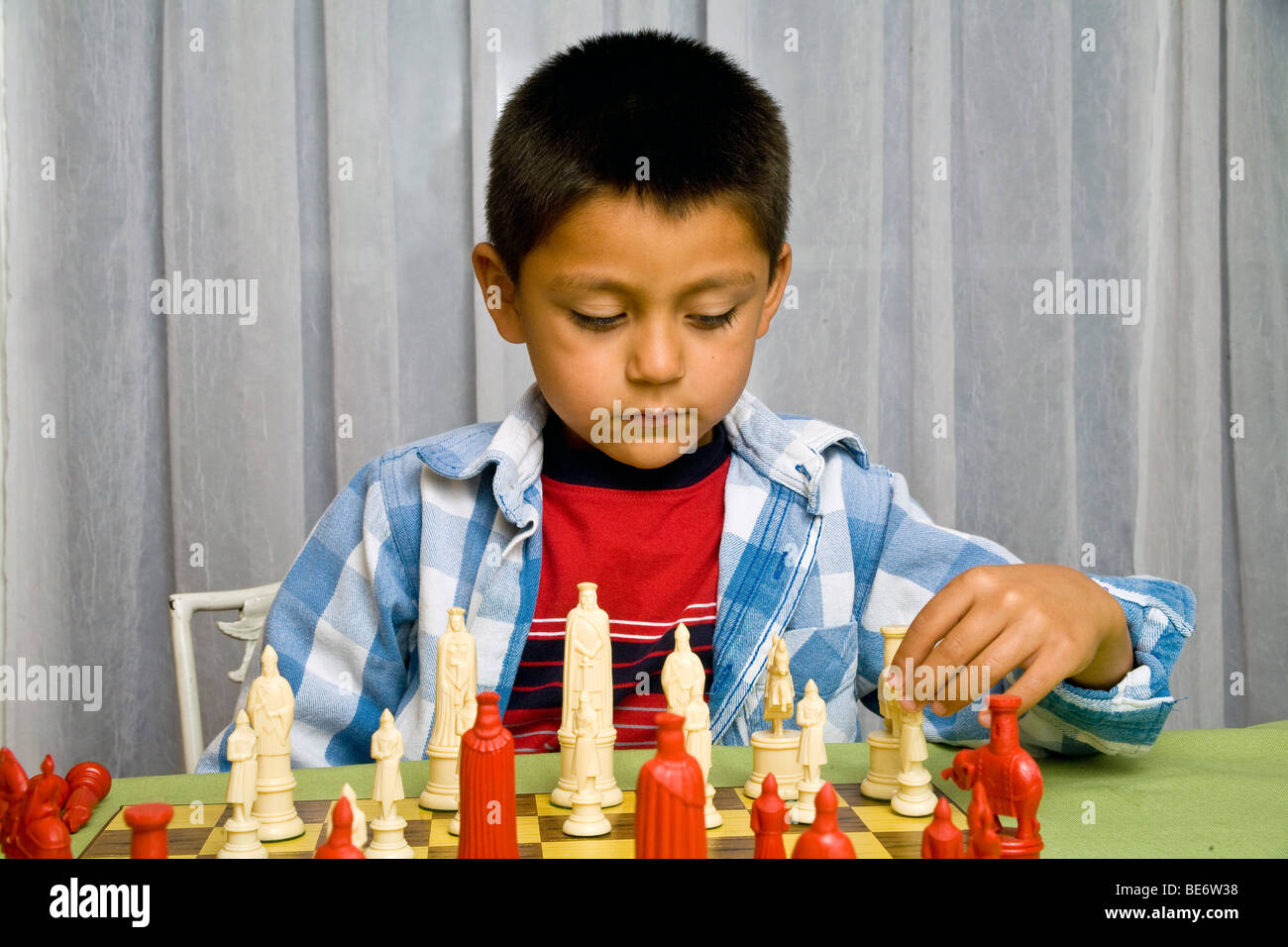 7-8 year old Hispanic boy learning to play chess. MR  © Myrleen Pearson Stock Photo