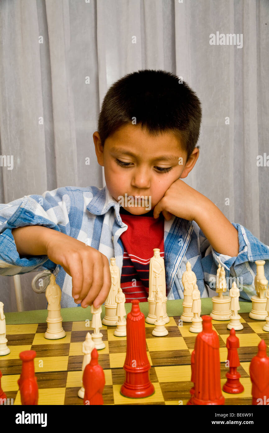 7-8 year old Hispanic boy learning to play chess. MR  © Myrleen Pearson Stock Photo