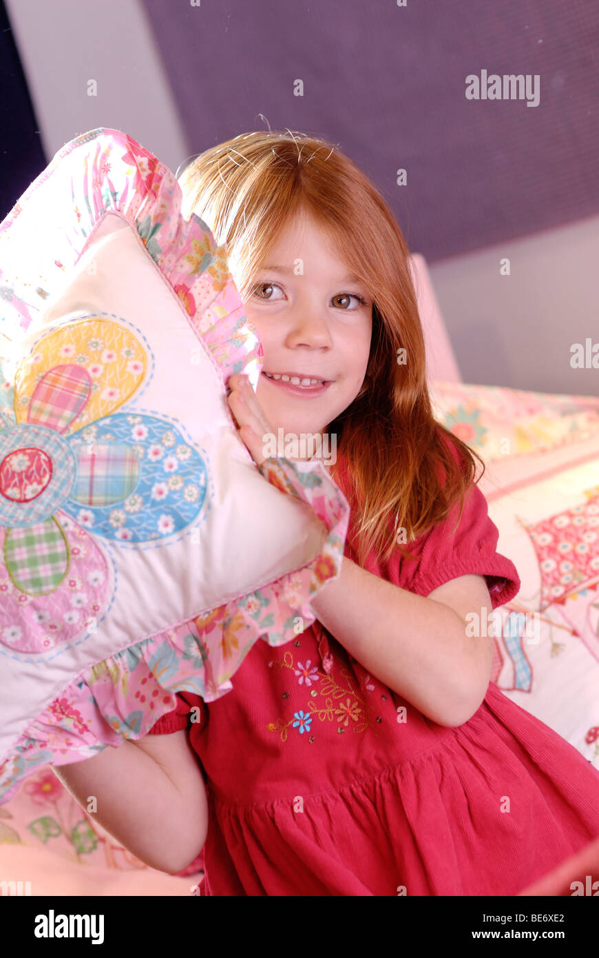 Little girl throwing a pillow, pillow fight Stock Photo Alamy