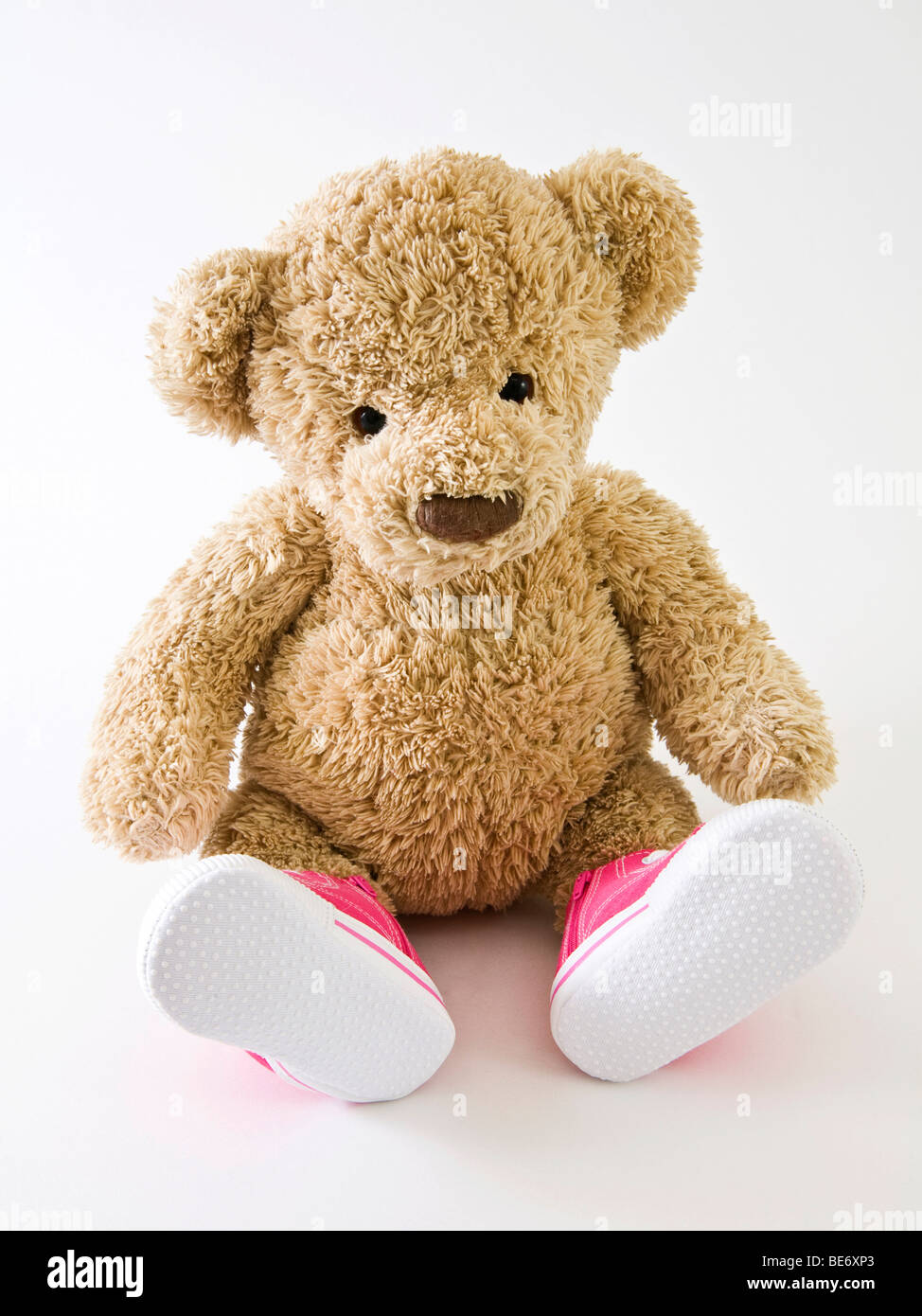 Teddy bear with baby shoes Stock Photo 