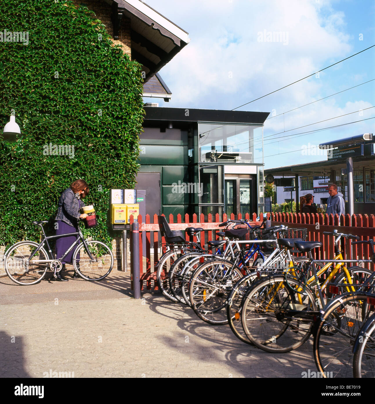 A woman taking her bicycle to the train at Gentofte Station, Copenhagen, Denmark Stock Photo