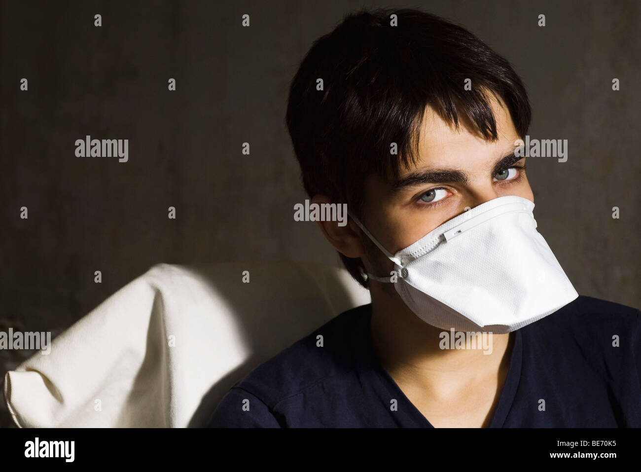 Teenage boy wearing flu mask, looking at camera Stock Photo
