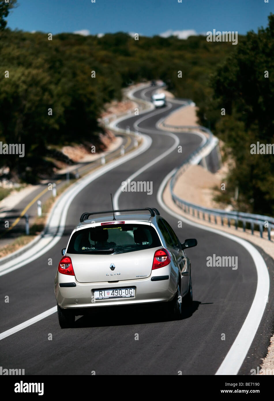 cars on twisty road on krk island, croatia Stock Photo