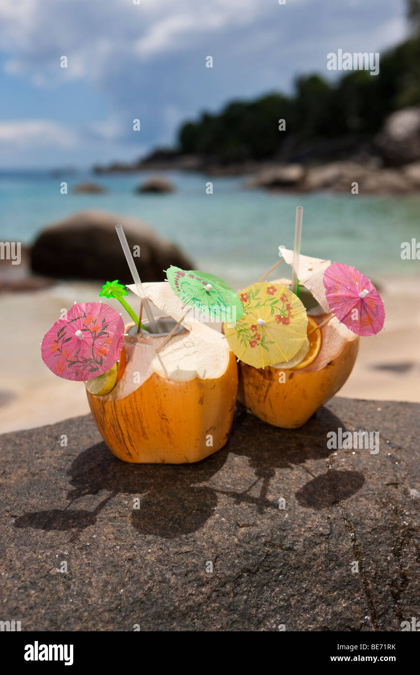 Two decorated coconuts filled with drinks standing on a granite rock, island Mahe, Seychelles, Indian Ocean, Africa Stock Photo