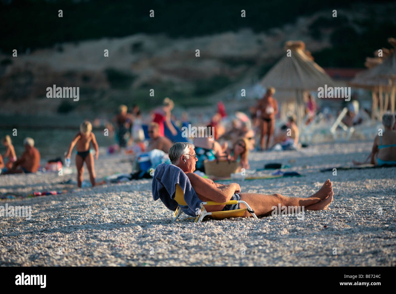 elderly man sunbathing in evening sun, bask, krk island, croatia Stock Photo