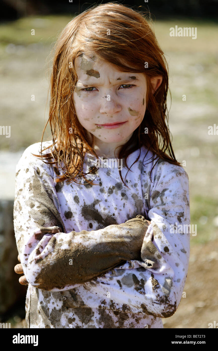 Child totally covered in mud, dirty, wild, untypical girl Stock Photo