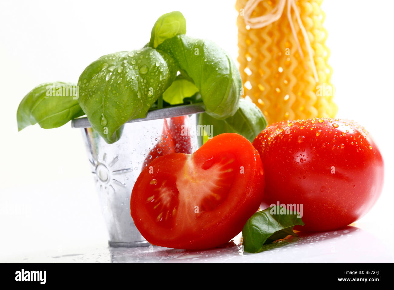 Tomatoes, one halved, with basil Stock Photo