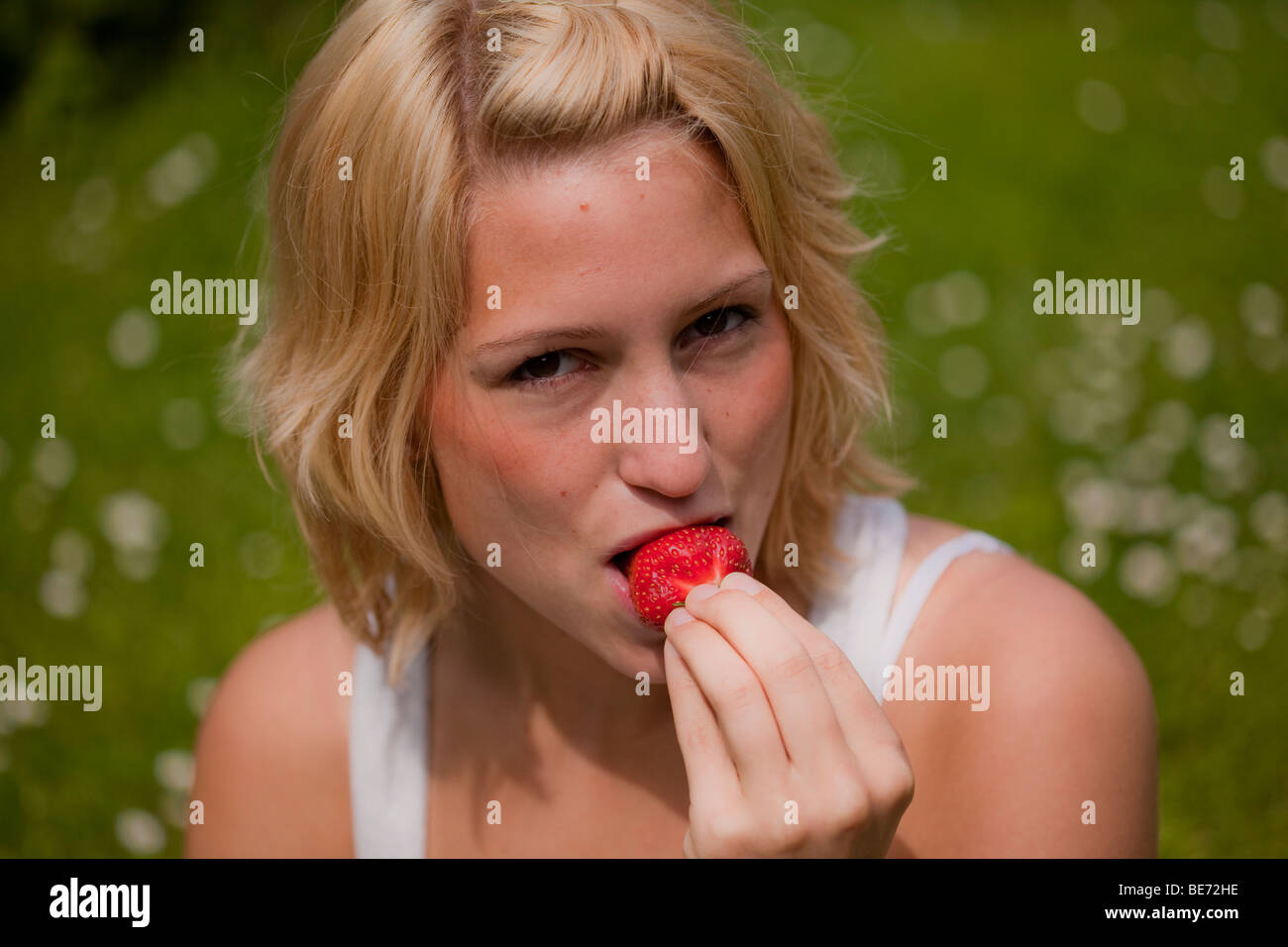 Young girl eating a strawberry Stock Photo