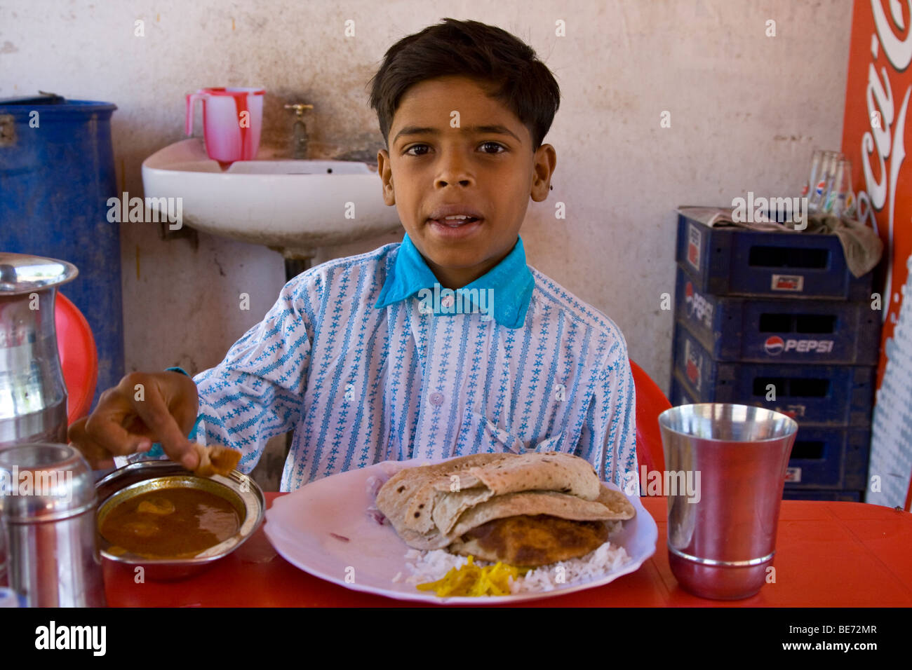 indian-boy-eating-daal-and-chapati-at-the-government-restaurant-at-BE72MR.jpg