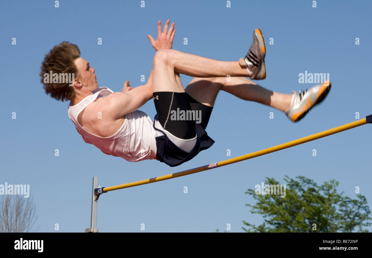 A high school boy wishes his body over the high jump bar at a track meet in Milwaukee, Wisconsin, USA. Stock Photo