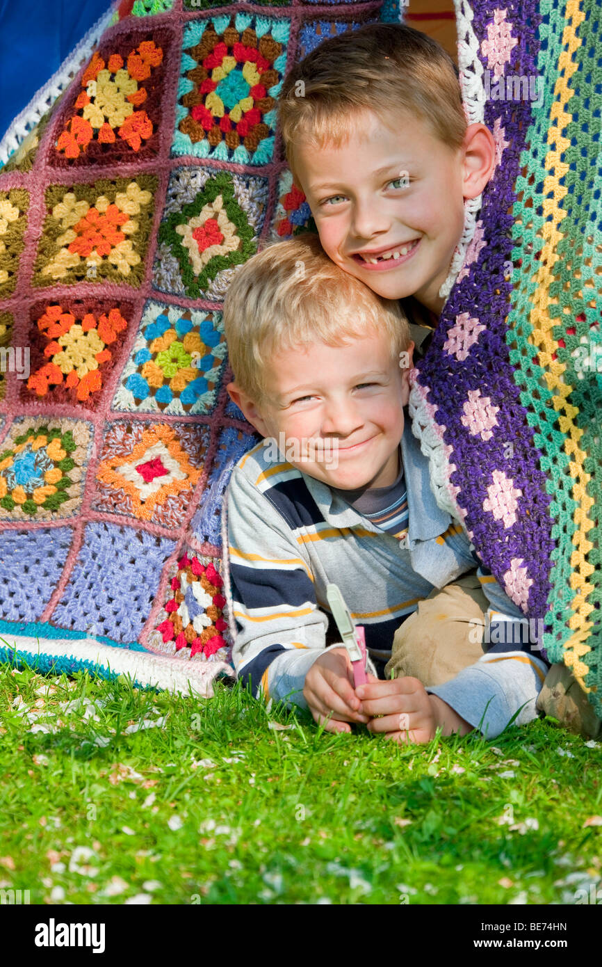 Two boys, 7 and 5, peering out of their tent Stock Photo