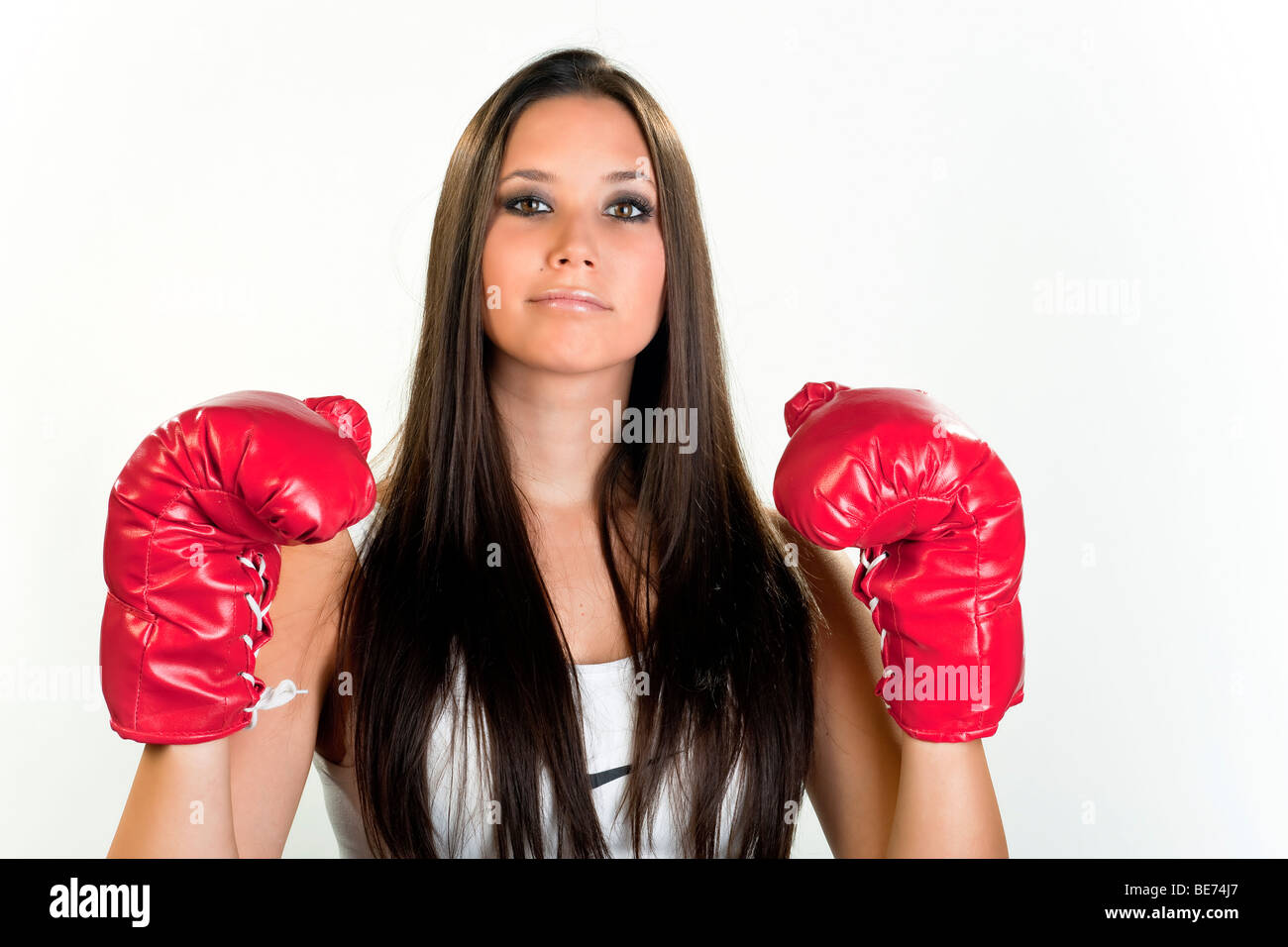 Young woman, 20, wearing boxing gloves and looking proud Stock Photo